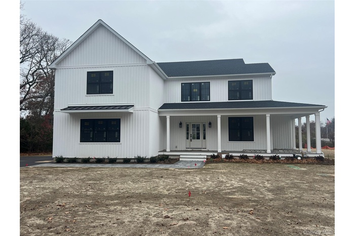View of front of property with covered porch and a shingled roof