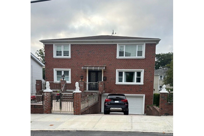View of front of property featuring brick siding, driveway, and an attached garage
