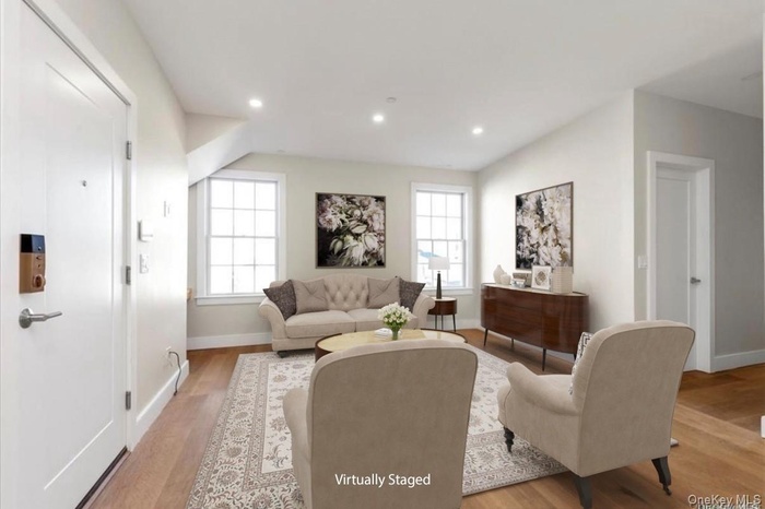 (Virtually Staged) Living room with light wood finished floors and recessed lighting