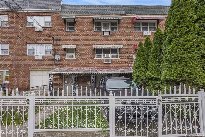 Traditional home with a fenced front yard, brick siding, and a garage