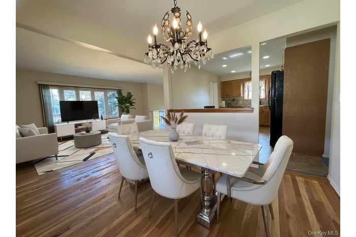 Dining space with light wood-style flooring, recessed lighting, and a chandelier