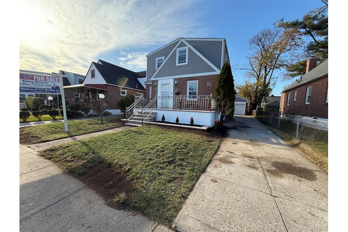 Bungalow-style house with an outdoor structure, brick siding, a detached garage, and concrete driveway
