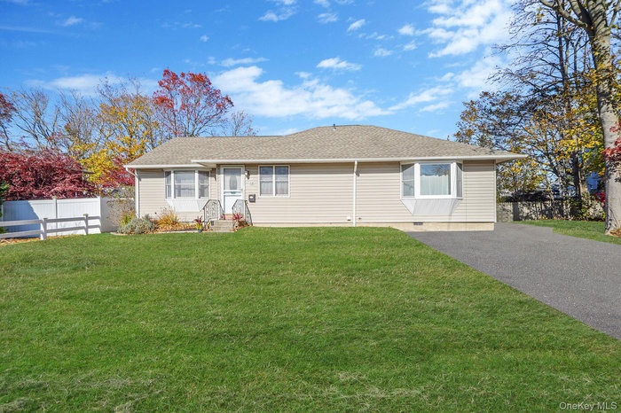 Ranch-style home with a shingled roof and driveway