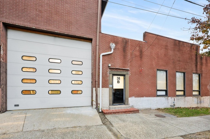 View of building exterior with a garage and concrete driveway