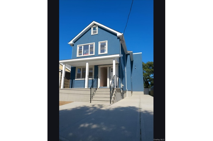 View of front facade with stucco siding and covered porch