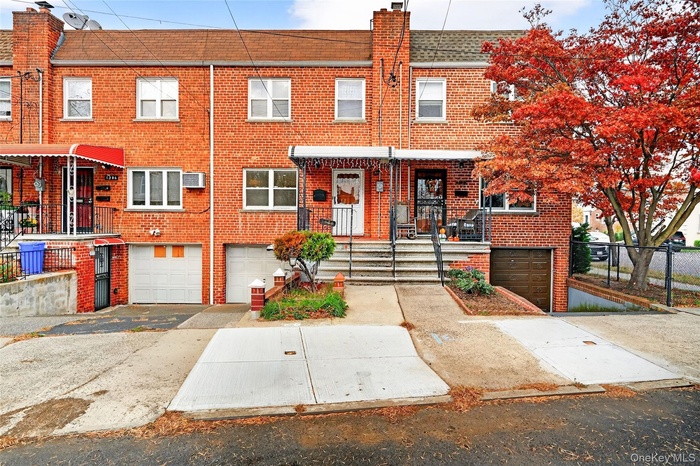 Traditional home featuring brick siding, driveway, roof with shingles, a chimney, and an attached garage
