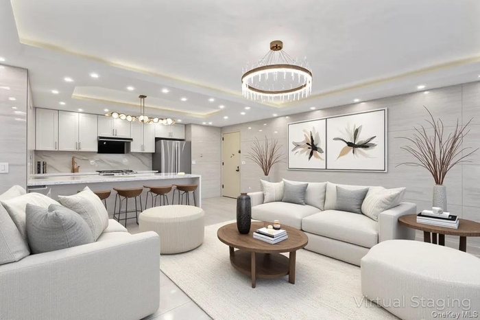 Living area with a tray ceiling, a chandelier, and recessed lighting
