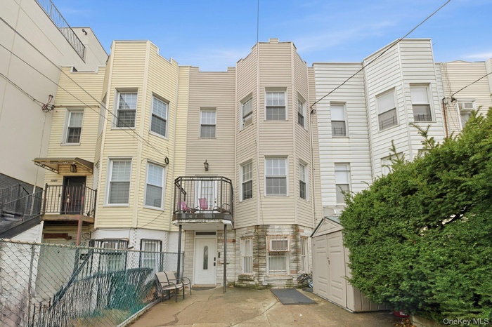 View of front facade with a storage unit, a balcony, and stone siding