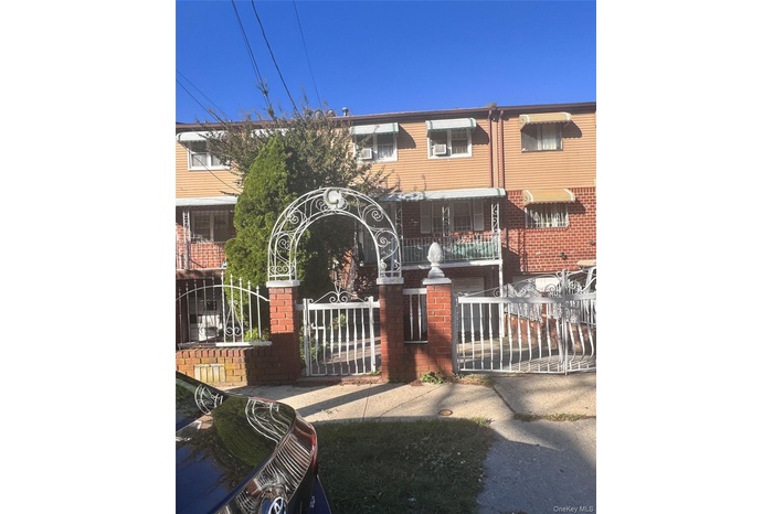 View of front of house featuring a fenced front yard, a gate, and brick siding