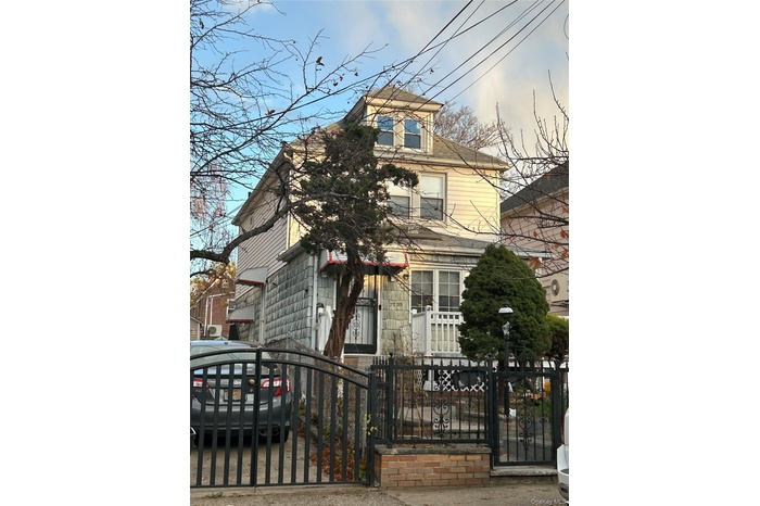 View of front of property featuring a fenced front yard and a gate