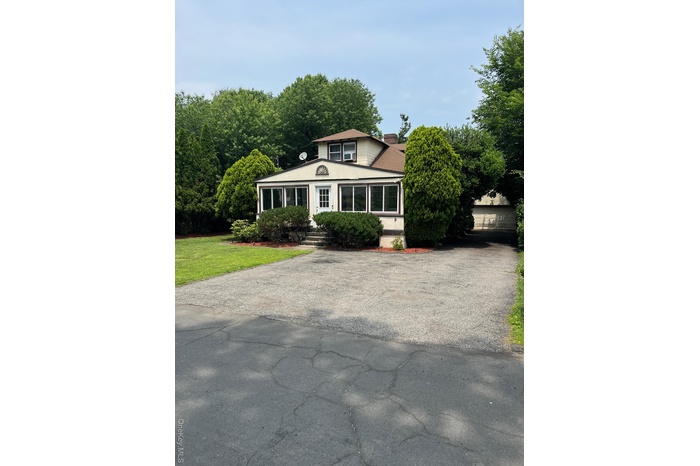 View of front of home featuring a chimney and a front yard