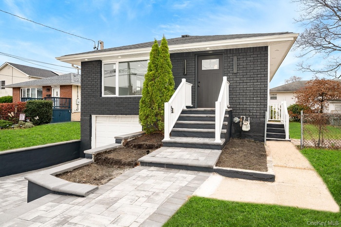 View of front of house featuring brick siding and a front yard