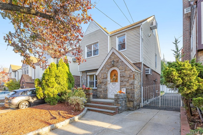Tudor home with a gate and stone siding