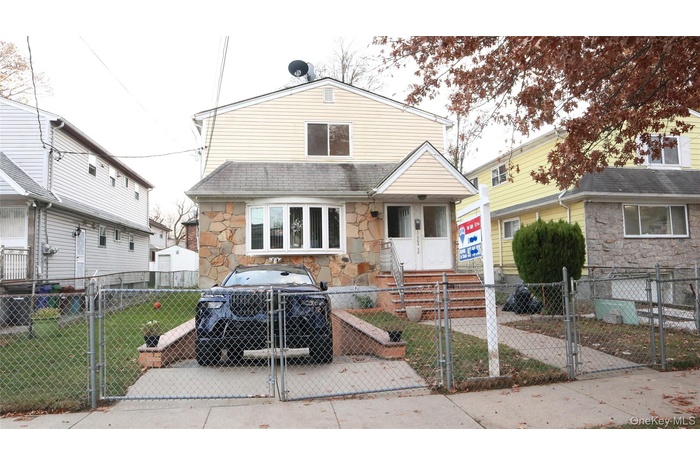 View of front of house with a gate, stone siding, and a fenced front yard