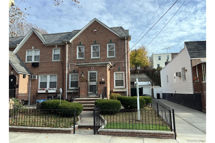 Traditional home featuring a fenced front yard, brick siding, and a gate