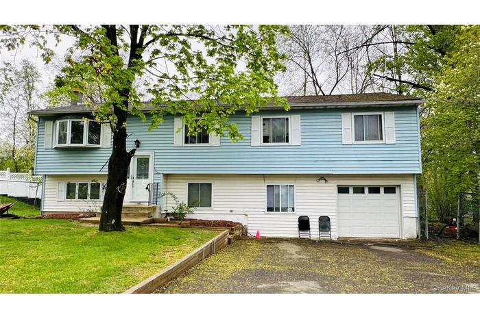 Rear view of property with asphalt driveway and a garage