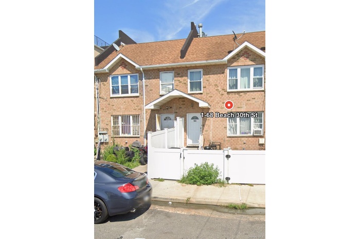 Traditional-style home with a fenced front yard, brick siding, and a shingled roof