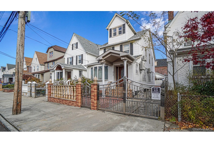 American foursquare style home with a residential view, a fenced front yard, and a gate