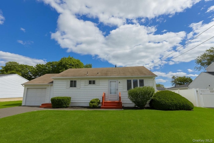 View of front of home with driveway, entry steps, and a garage