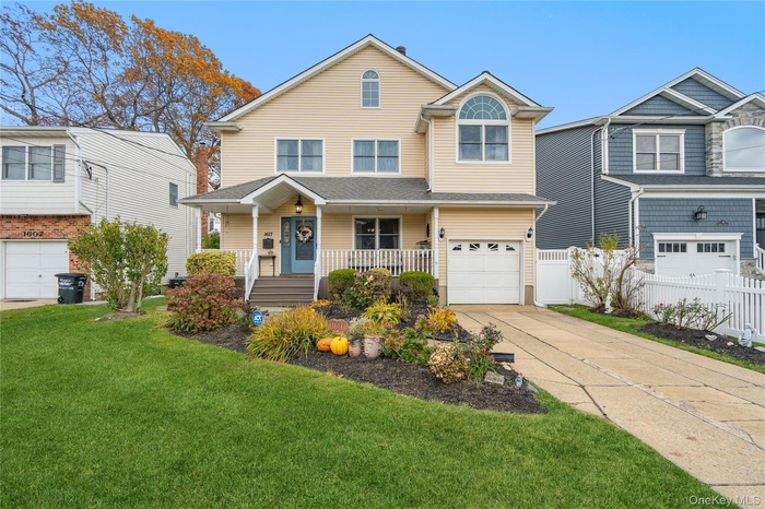 View of front of property featuring covered porch, driveway, and an attached garage