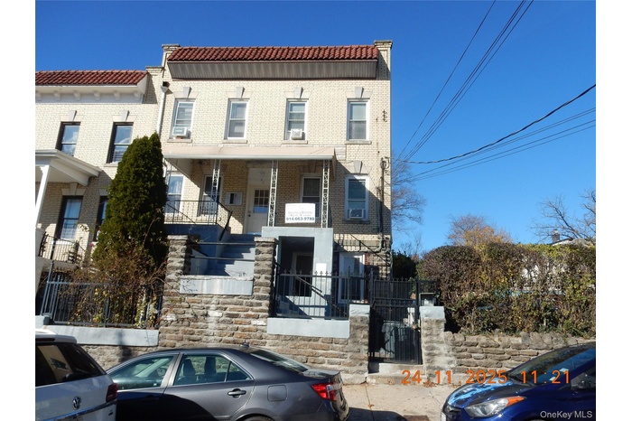 View of front of property featuring covered porch, stairs, a tile roof, brick siding, and a gate