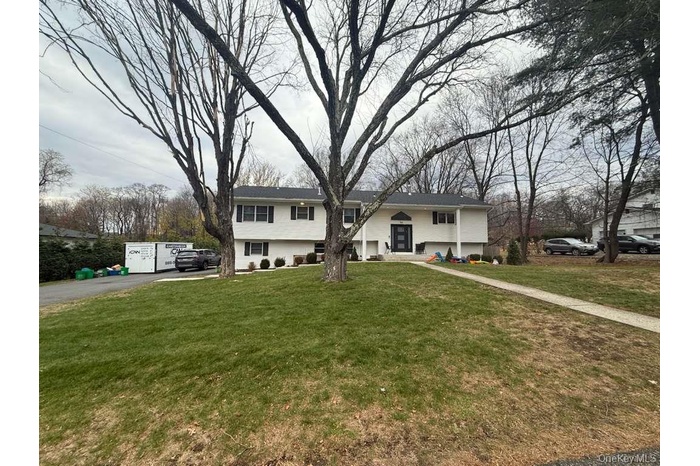 Bi-level home with a front yard and asphalt driveway