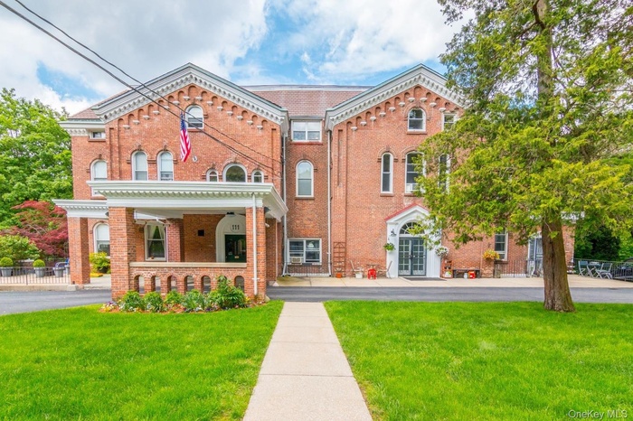 View of front of home featuring a front yard, brick siding, and a porch