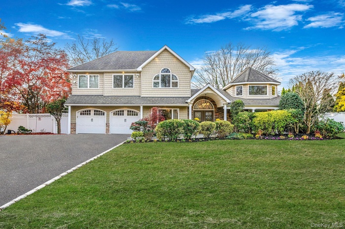 Shingle-style home featuring asphalt driveway, a garage, roof with shingles, and stone siding