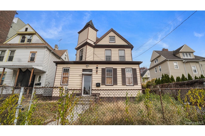 View of front facade featuring a fenced front yard and a gate