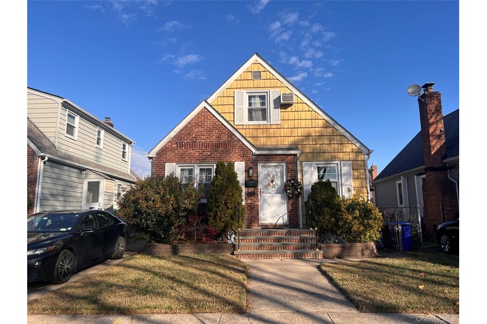 Bungalow-style house with brick siding and a front yard