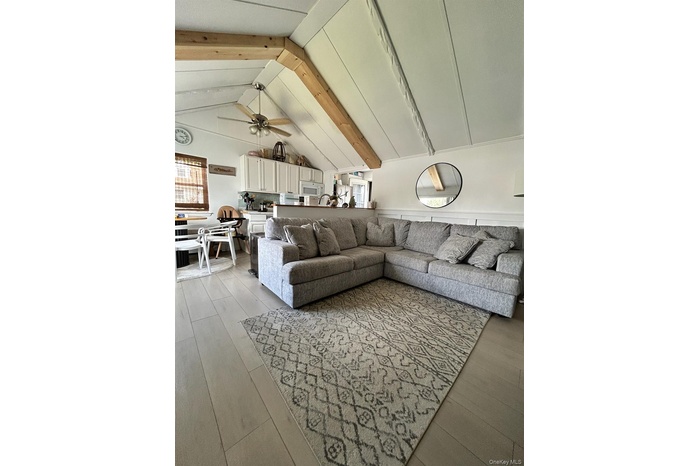 Living room featuring ceiling fan and light wood-style flooring