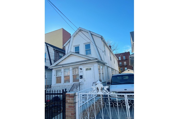 Dutch colonial featuring a fenced front yard, a gambrel roof, and a gate