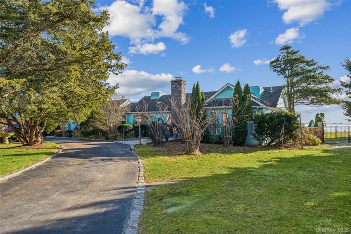 View of front of house featuring a front yard and asphalt driveway