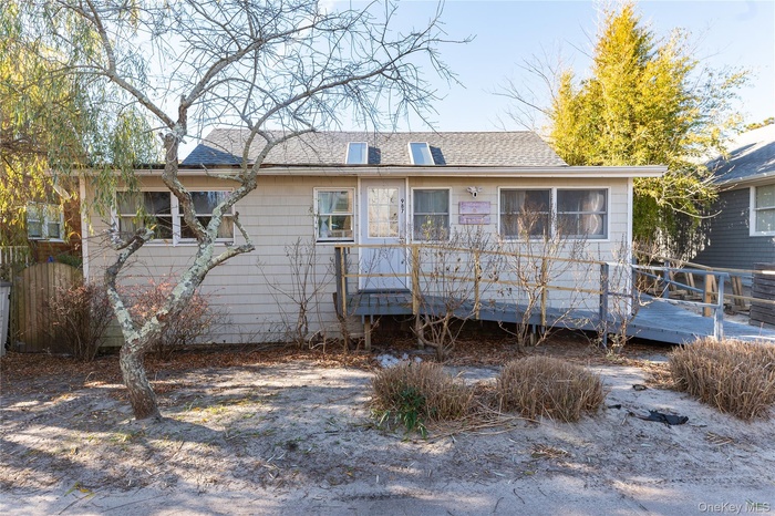 Back of property featuring a wooden deck and a shingled roof