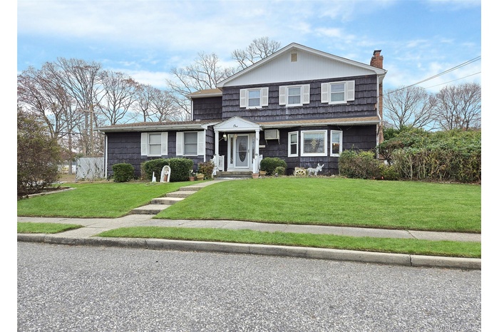 View of front of house featuring a front yard and a chimney