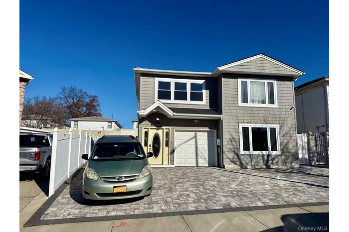 View of front of home with decorative driveway and an attached garage