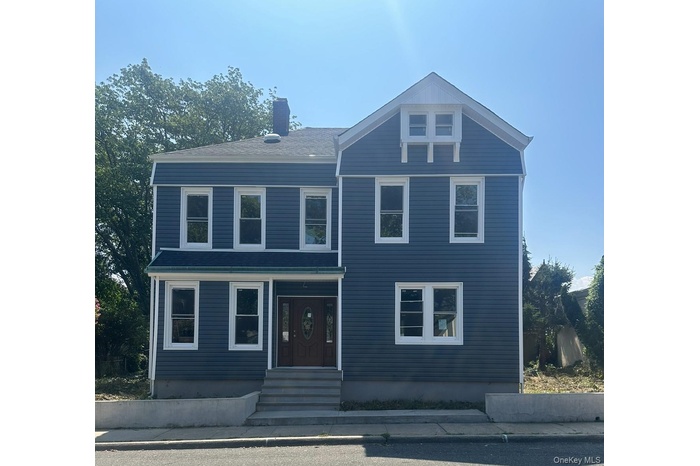 View of front of home with a chimney, a shingled roof, and entry steps