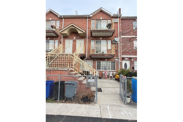 View of front facade featuring brick siding, a fenced front yard, and a gate