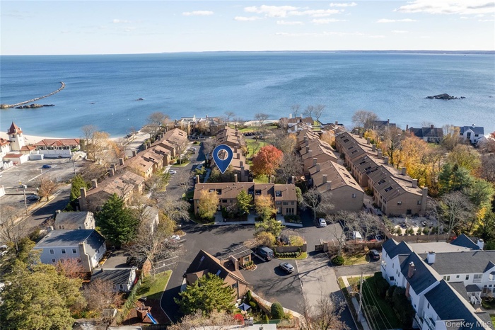 Aerial view of property's location featuring a large body of water and nearby suburban area