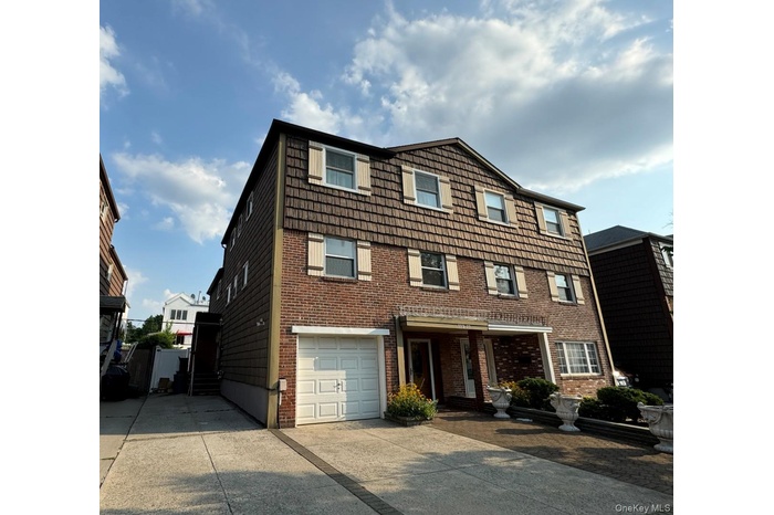 View of front of home featuring driveway, brick siding, and a garage
