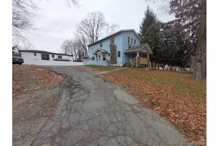 View of front of home featuring asphalt driveway and a garage