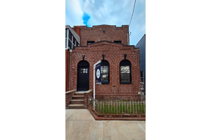 View of front of property with brick siding and a fenced front yard