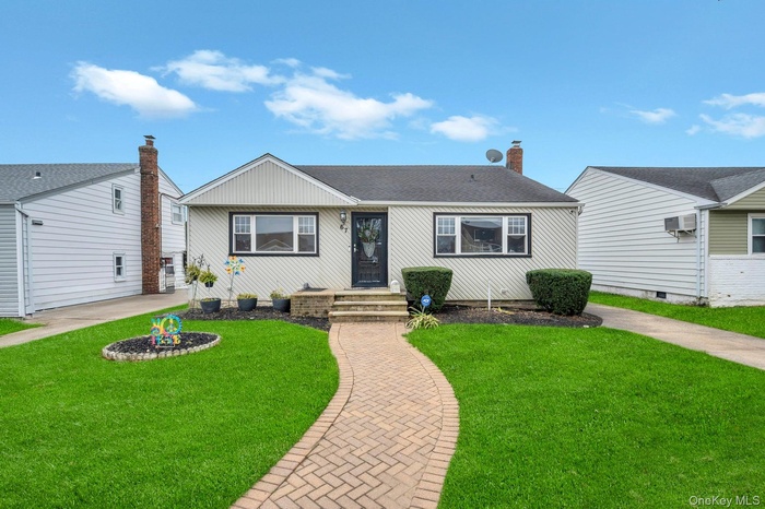 Ranch-style house featuring a front lawn, a shingled roof, and a chimney