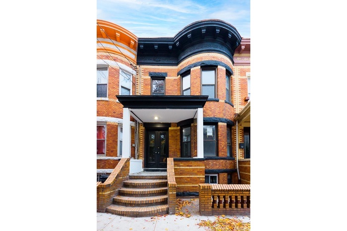 Entrance to property with brick siding, french doors, and covered porch