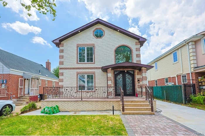 View of front of home featuring brick siding and french doors