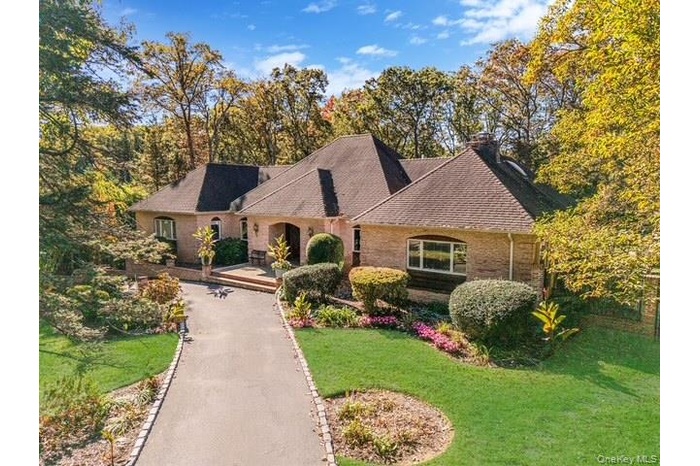 French country style house featuring a front yard, brick siding, and roof with shingles
