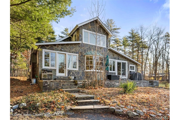 Rear view of property with stone siding and entry steps