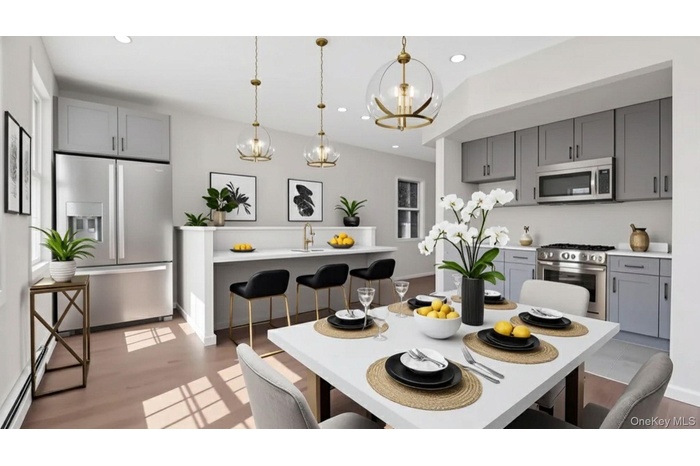 Kitchen featuring gray cabinets, a kitchen bar, stainless steel appliances, and recessed lighting