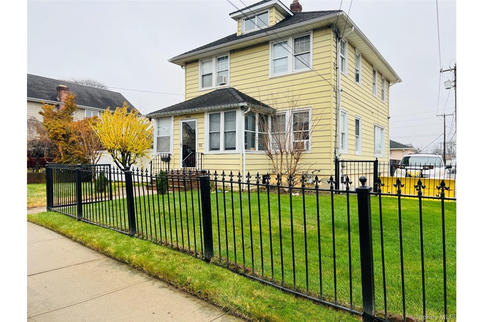 Traditional style home featuring a fenced front yard and a chimney