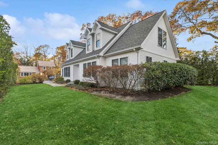 View of side of home featuring a yard and a shingled roof